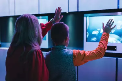 woman and boy interacting with display